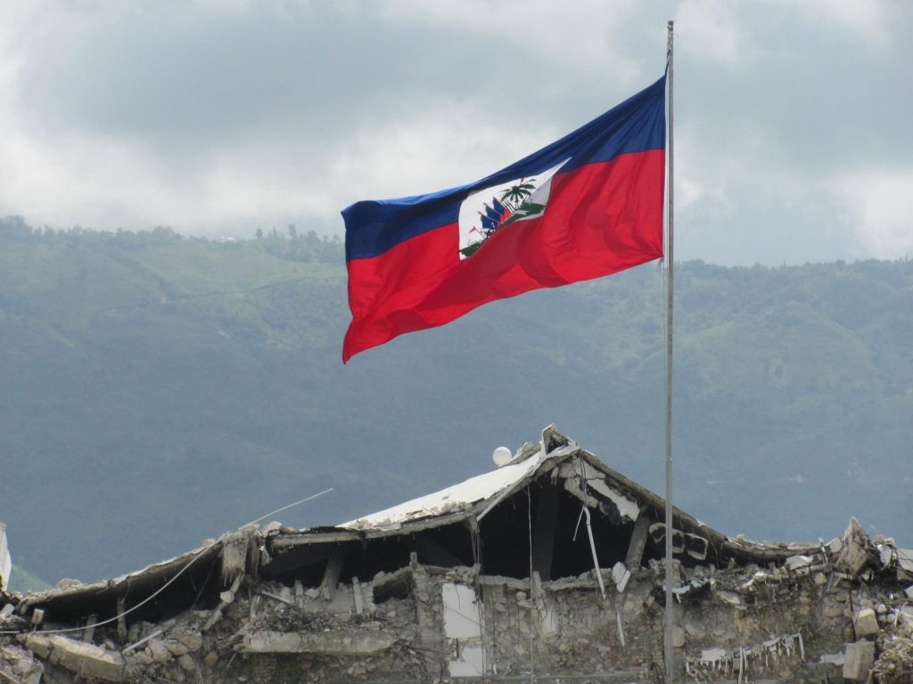 Haiti flag flies over rubble