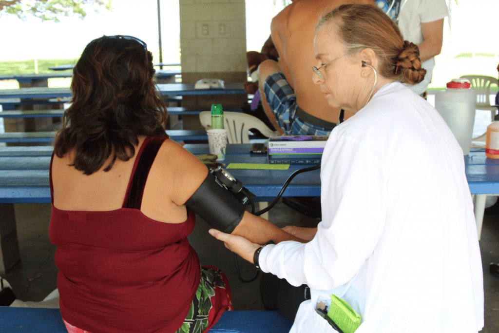 UH Maui nurse and instructor Carol Petith-Zbiciak performs a blood pressure test on a woman.