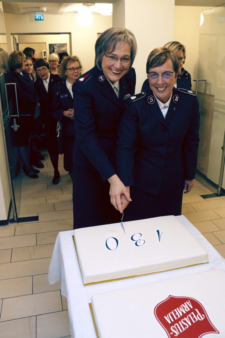 Rosalie Peddle and Salvation Army Officer cutting cake
